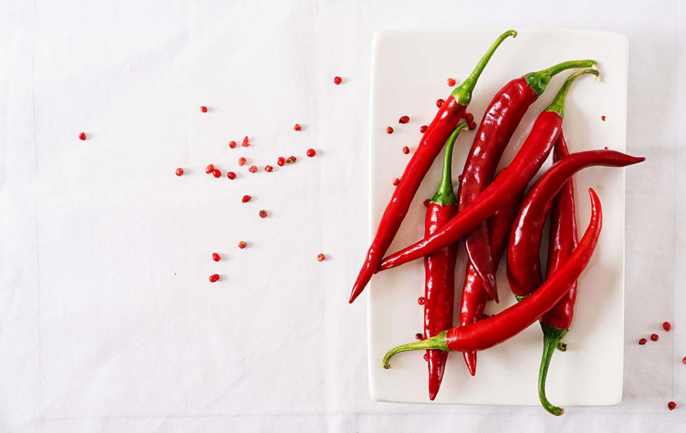 Red hot chili peppers in plate on white table
