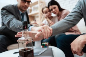 Psychologist hold patient hand alcoholism problem