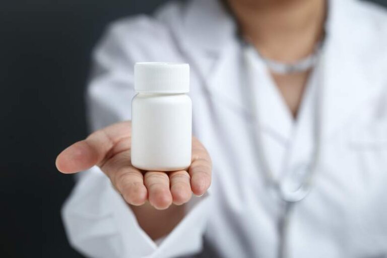 Female doctor holding and showing a medicine bottle