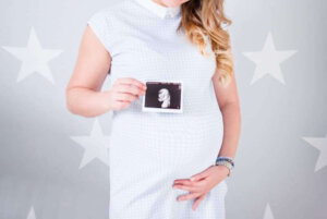 Preganant-woman-holding-ultrasound-result