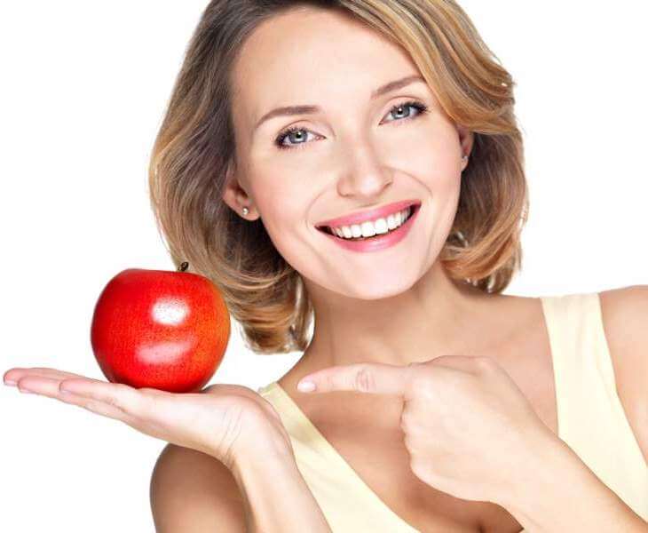 young beautiful smiling woman pointing the finger at apple