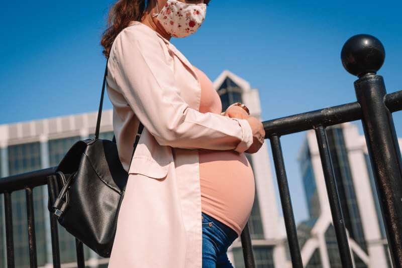 pregnant-woman-wearing-a-face-mask-on-a-street